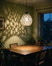 Organic Hole Pendant Light – at night on a bedside table