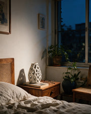 Oval Perf Vase – at night on a bedside table