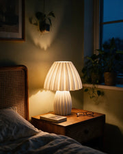 Polka Pleat Table Lamp – at night on a bedside table