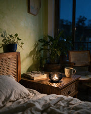 Spiral Tealight Holder – at night on a bedside table