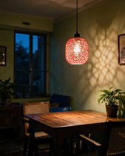 Web Capsule Pendant Light – at night on a bedside table